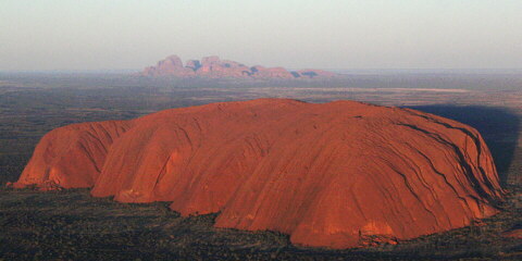 Panorámica con Uluru en primer plano y Kata Tjuta al fondo.