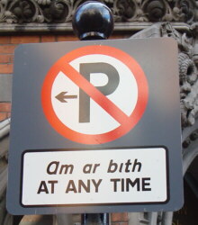 Señalización bilingüe prohibiendo aparcar.